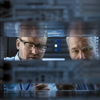zoom sur le visage de deux hommes observant l'intérieur d'une machine