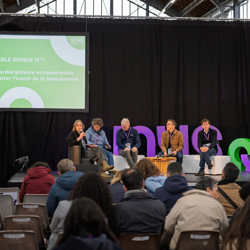 La table ronde a commencé. L'animatrice parle au micro pour donner le contexte