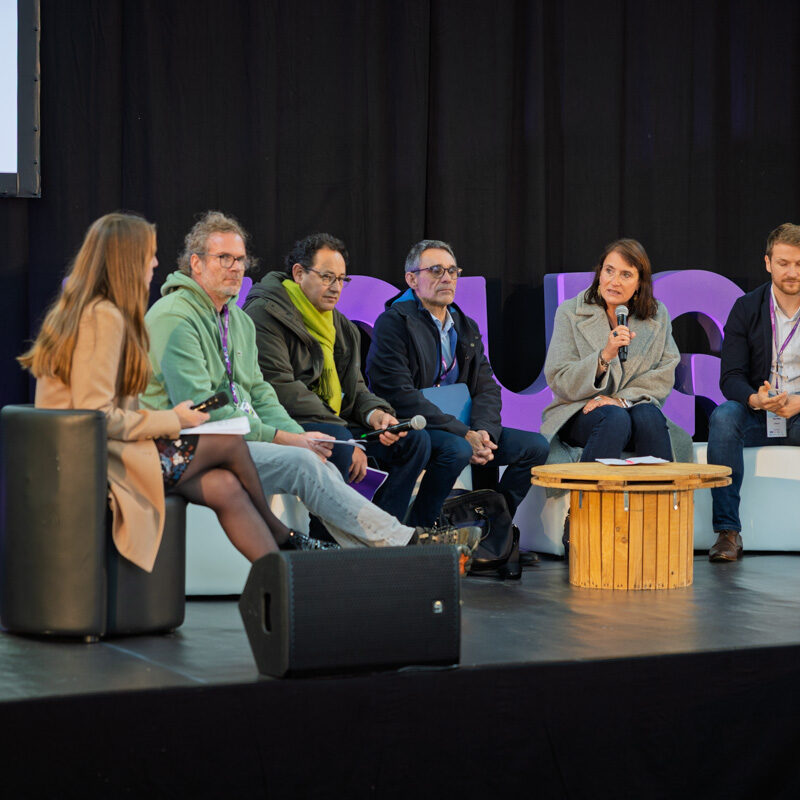 Christine Morin continue de répondre à la question de l'animatrice en parlant dans le micro. Les autres écoutent
