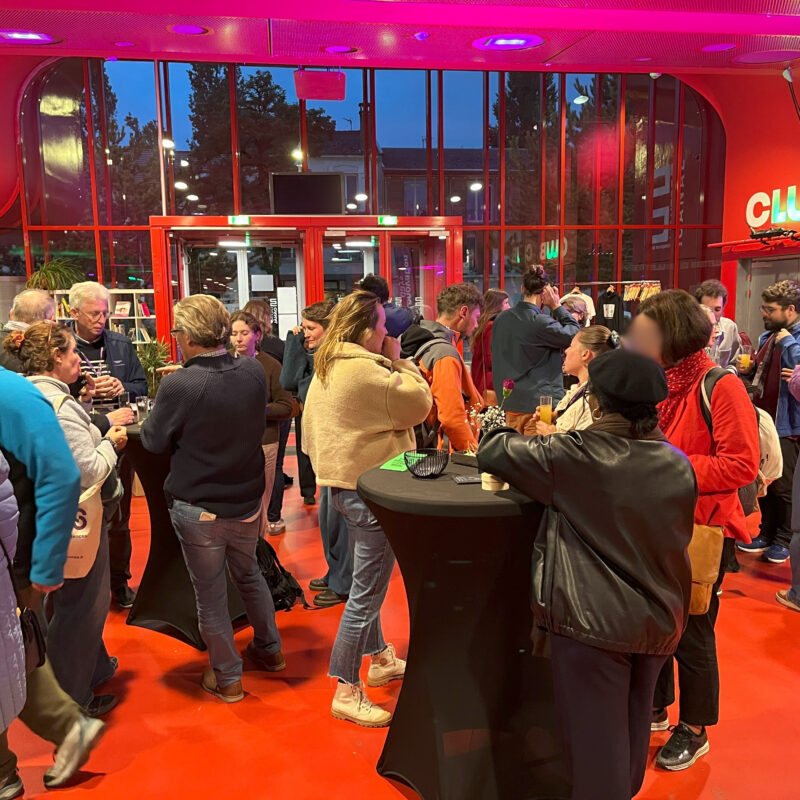 photo du cocktail de clôture dans le fil rouge de l'Autre Canal. Il y a beaucoup de monde et des manges debout. Ils sont entrain de manger et d'échanger entre eux